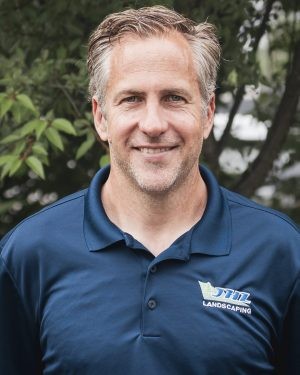 Drew Reish, General Manager of JHL Landscape Lighting, in a navy JHL polo outdoors in Newtown Square, PA