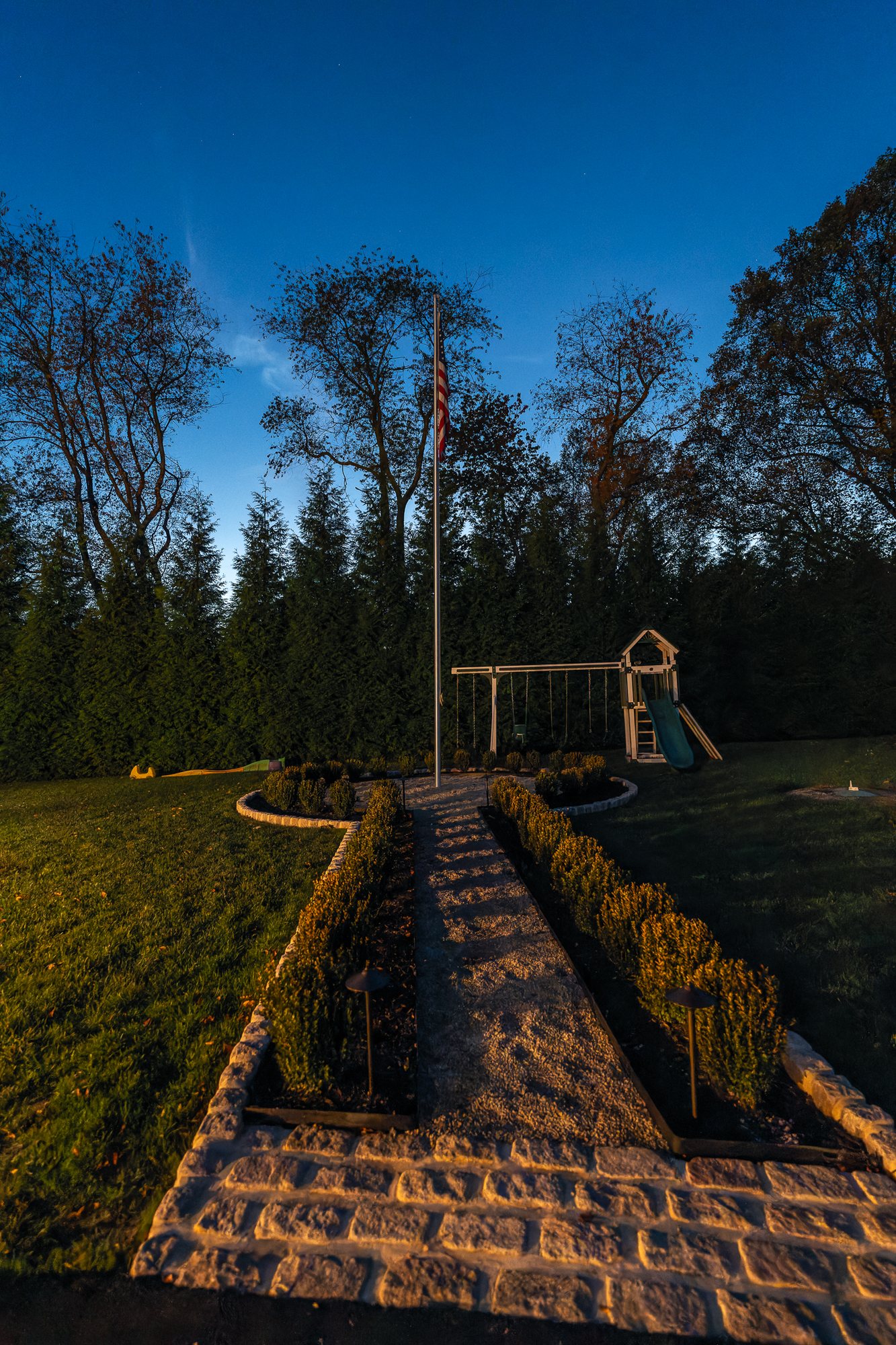 Lit stone walkway and garden path at dusk — path lighting serving Newtown Square, PA