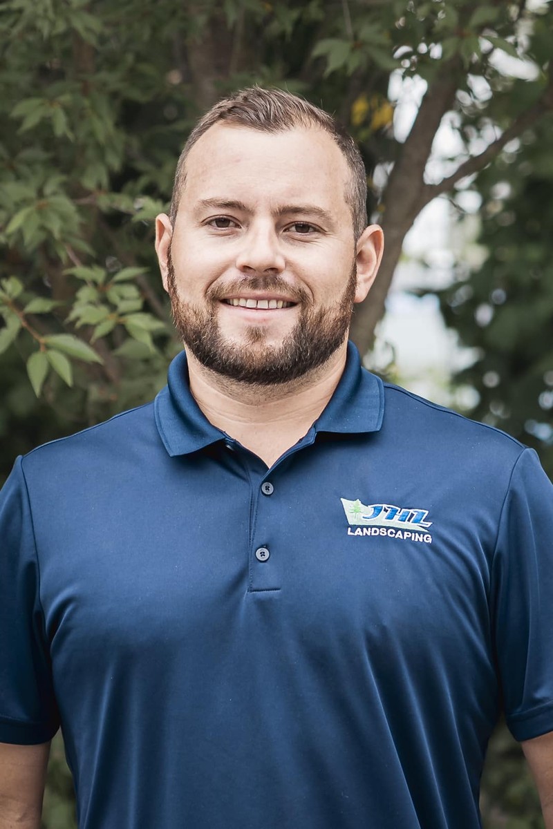 Sean Arrell, Operations Manager of JHL Landscape Lighting, in a navy JHL polo outdoors in Newtown Square, PA