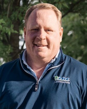 TJ Warner, owner of JHL Landscape Lighting, in a navy JHL pullover outdoors in Newtown Square, PA
